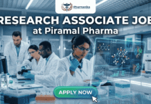Research Associate Job at Piramal Pharma | Latest M Pharm Vacany You Can’t Miss Research Associate Job at Piramal Pharma. A professional and vibrant featured image for a Research Associate Job at Piramal Pharma. It depicts a focused scientist in a sleek, modern pharmaceutical laboratory working with a digital AR interface showing chemical compounds and data charts. Other researchers are visible in the background. The Biotecnika logo is at the top, and a bright green "Apply now" button with a cursor click icon is at the bottom.